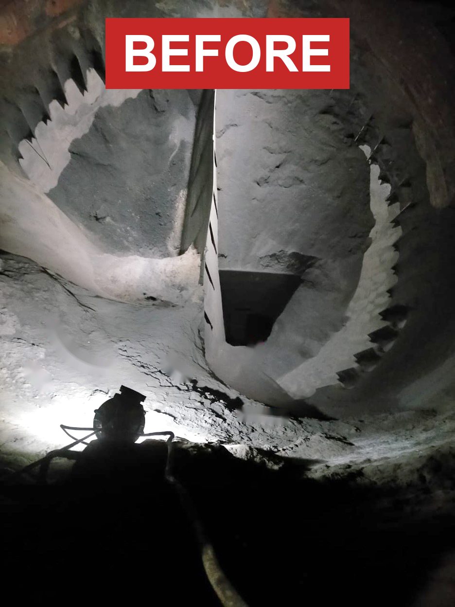 Coal bunker before cleaning — hardened coal build-up covering the bunker wall and restricting flow
