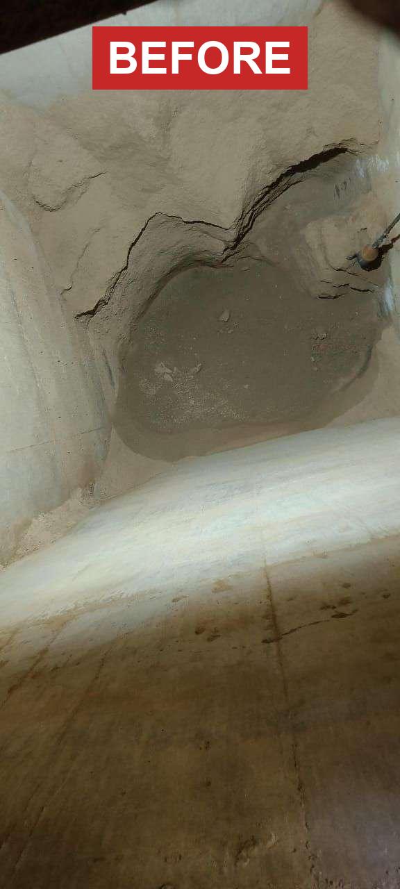 Hopper before cleaning — material bridged solid across the outlet blocking all flow