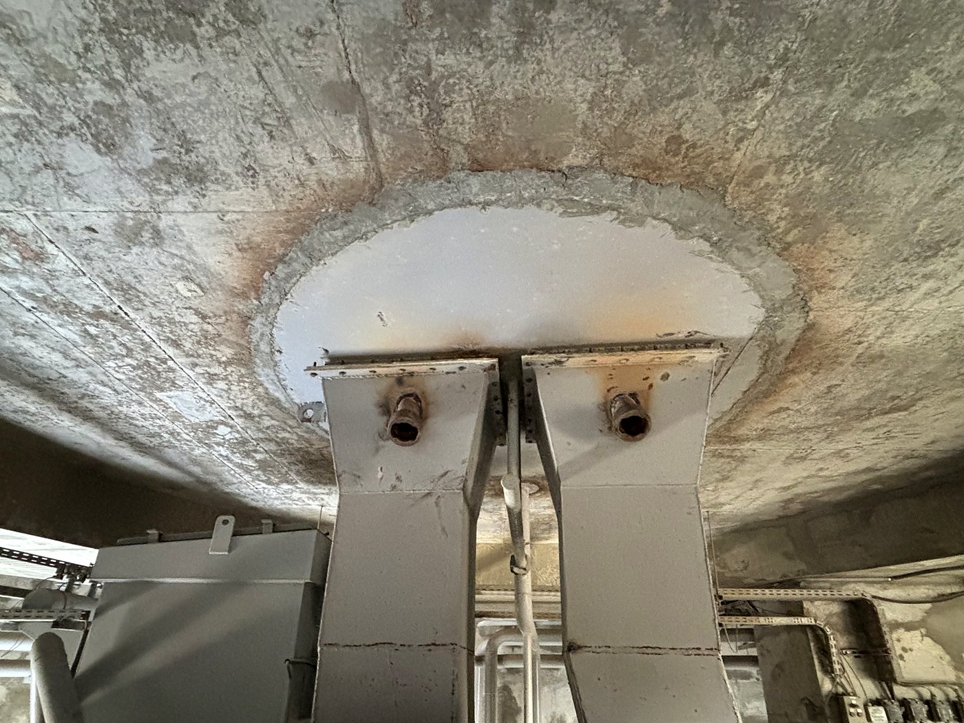 Looking up at the underside of a silo discharge cone showing the twin extraction chutes with Cardox sockets fitted on each side