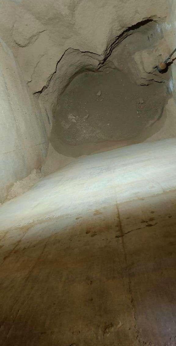 Ash hopper before cleaning — material bridged solid across the outlet, blocking all flow