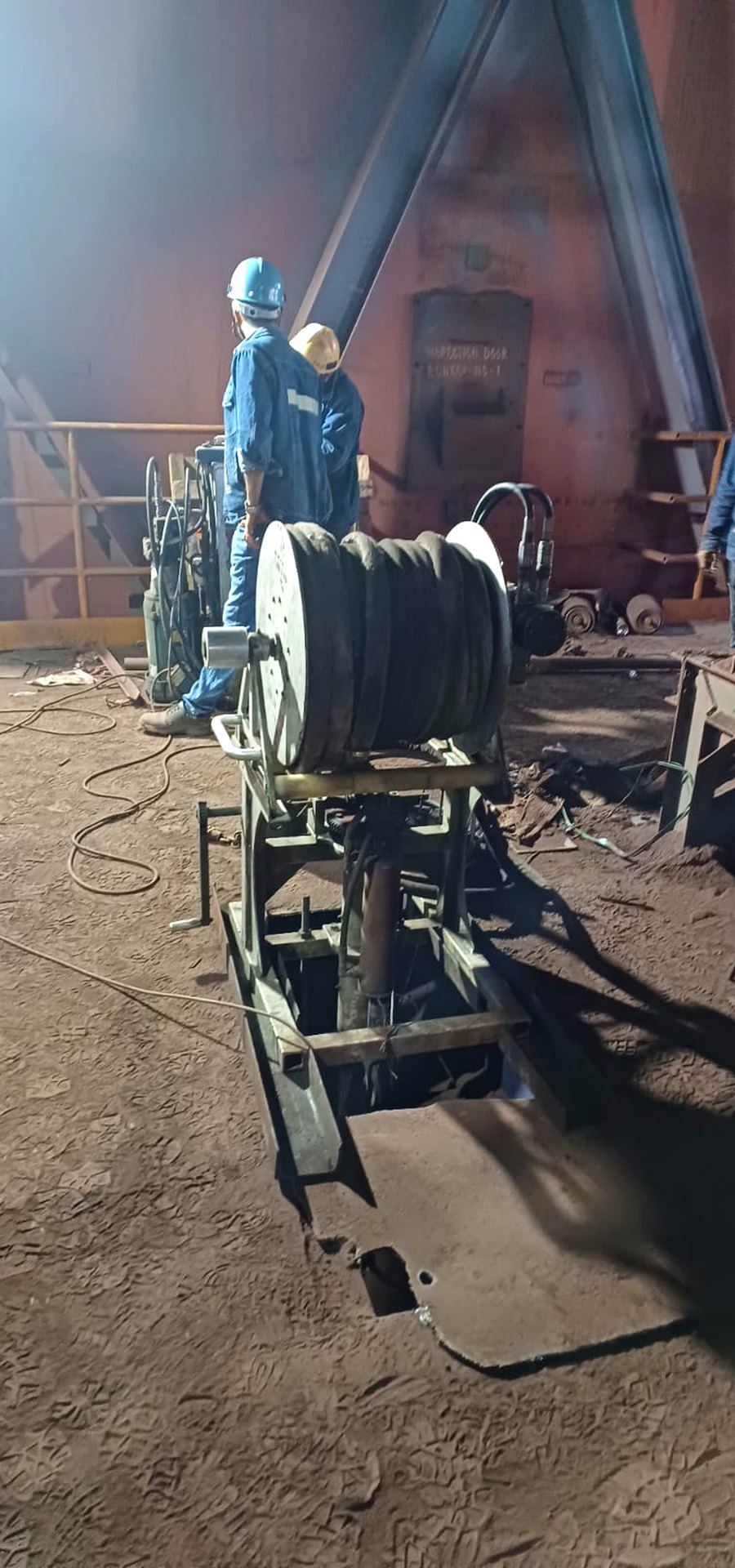 A Cardox India whipping machine set up over a bunker access opening, hose reel and boom in place, crew standing outside the vessel